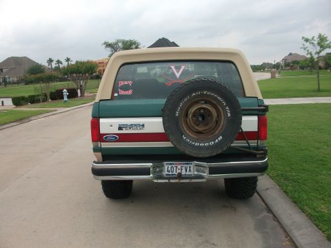 1989 Ford Bronco - This 1989 Ford Bronco is seen from the rear, a spare tire mounted on the tailgate and a two-tone green and tan paint scheme.