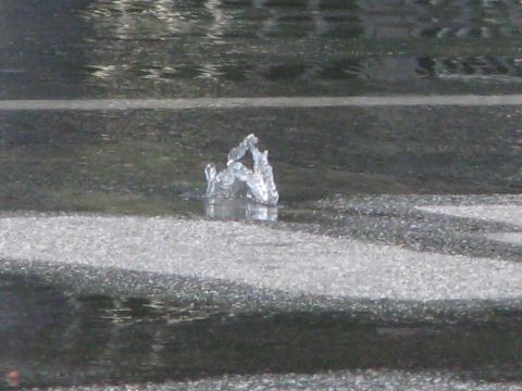 1968 Ford Mustang - A water main break causes water to erupt from the asphalt on a street.