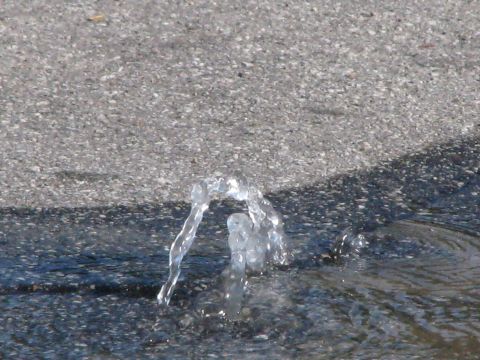 1968 Ford Mustang - A water main break causes water to erupt from the asphalt surface.