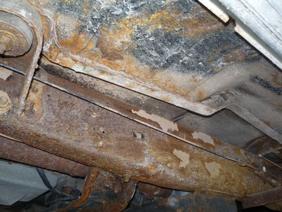 Rusted undercarriage frame with visible suspension components