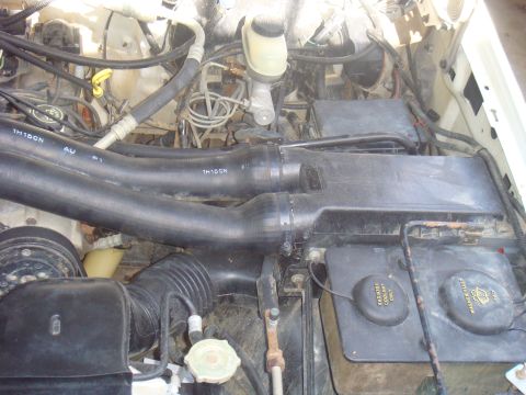1992 Ford Bronco - Close-up view of an engine bay, showing hoses, fluid reservoirs, and other engine components.