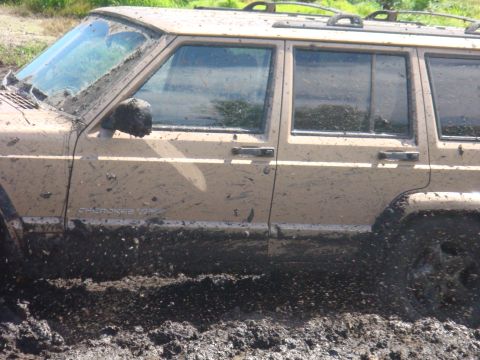1992 Ford Bronco - This Jeep Cherokee XJ is stuck in the mud, with "Cherokee XJ" visible on the door.