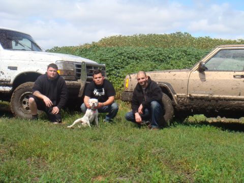 1992 Ford Bronco - Three men and a dog pose with two off-road vehicles after a muddy excursion.