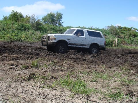 1992 Ford Bronco - White 1992 Ford Bronco struggling in deep mud off-road.