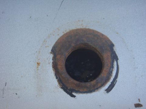 1992 Ford Bronco - A close-up view of a rusted hole on a light-colored surface, with a Supermotors.net watermark visible.