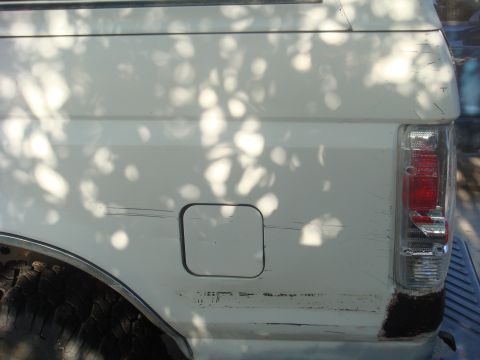 1992 Ford Bronco - Rear view of a white 1992 Ford Bronco showing the quarter panel and taillight.