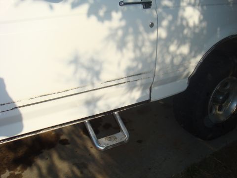 1992 Ford Bronco - Side view of a white 1992 Ford Bronco, showing the door, running board, and wheel.