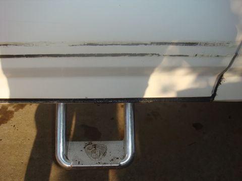1992 Ford Bronco - Close-up of a chrome step bumper with a textured pad on a white vehicle.