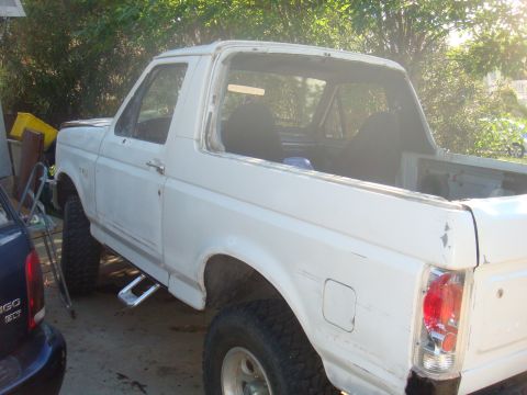 1992 Ford Bronco - This white 1992 Ford Bronco is seen from a 3/4 front angle, with its rear window removed.