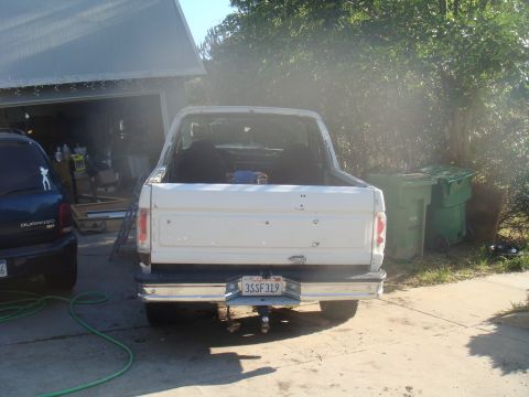 1992 Ford Bronco - White pickup truck parked in a driveway next to a dark SUV. License plate is visible.
