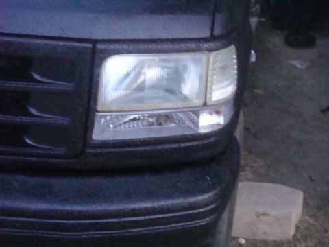 1992 Ford Bronco - The front corner of a 1992 Ford Bronco is visible, its headlight and textured grille.