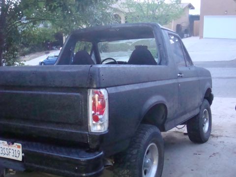 1992 Ford Bronco - Rear view of a black 1992 Ford Bronco, showing its removable top and license plate.