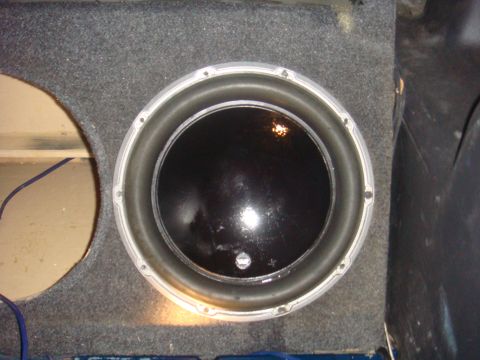 1992 Ford Bronco - A close-up view of a subwoofer speaker installed in a vehicle's cargo area.