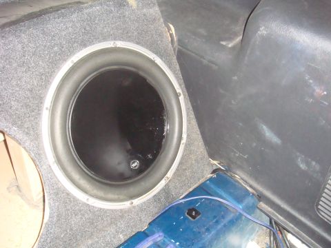 1992 Ford Bronco - A close-up view of a car's interior reveals a large subwoofer installed in a custom enclosure.