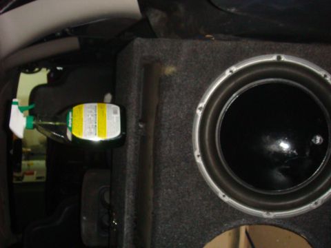 1992 Ford Bronco - A spray bottle is attached to the interior panel next to a large subwoofer in this vehicle.