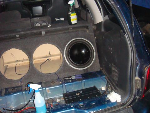 1992 Ford Bronco - The trunk of a car is shown with a custom subwoofer installation, including one active subwoofer and two empty enclosures.