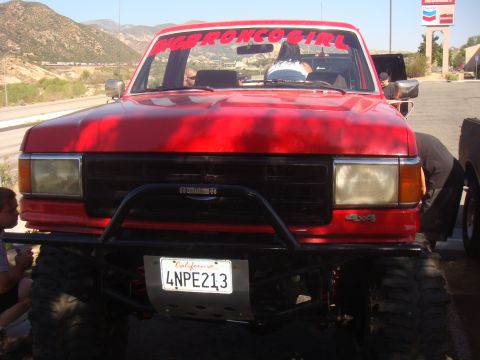 1992 Ford Bronco - This red 1992 Ford Bronco has a bull bar and "BRONCO GIRL" banner on the windshield.
