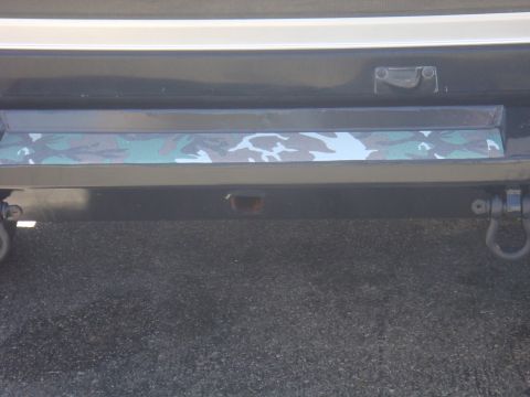 1992 Ford Bronco - Close-up of a vehicle's rear bumper a camouflage accent strip and tow hooks.