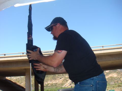 1992 Ford Bronco - Man holding a rolled-up object under a bridge with a clear blue sky in the background.