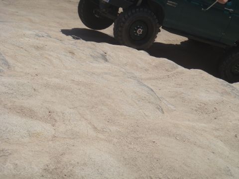 1992 Ford Bronco - Vehicle navigates a steep, sandy incline with large off-road tires.