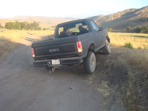 1992 Ford Bronco - This 1992 Ford Bronco is seen from the rear on a dusty trail, with hills in the background.