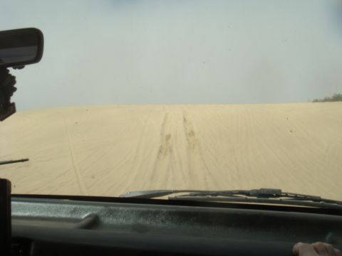 1992 Ford Bronco - Driving through sand dunes with tracks ahead on the sandy terrain.