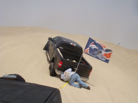 1992 Ford Bronco - Stuck in the sand with a Broncos flag. Recovery in progress.