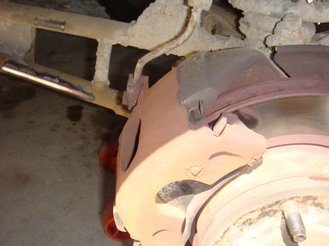 1992 Ford Bronco - Vehicle brake caliper and rotor assembly, showing wear and rust.