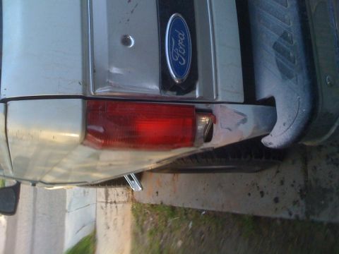 1992 Ford Bronco - Rear view of a silver SUV, identified by its Ford emblem and taillight design, consistent with a 1992 Ford Bronco.