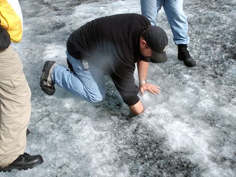 1996 Ford Bronco - Several individuals are gathered on a surface of ice and snow, with one person kneeling and probing the icy ground.