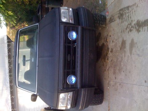 1992 Ford Bronco - This 1992 Ford Bronco is parked outdoors, showing its front grille and headlights.