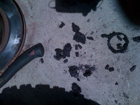 1992 Ford Bronco - Brake rotor and debris on concrete, possibly from a vehicle repair.