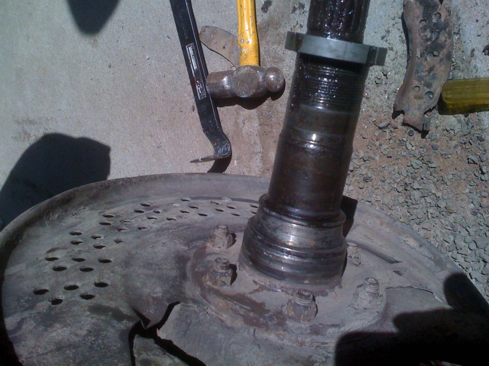 close-up of vehicle axle and brake rotor with tools nearby
