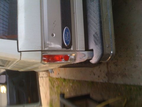 1992 Ford Bronco - Rear view of a white 1992 Ford Bronco, showing the taillight and bumper detail.