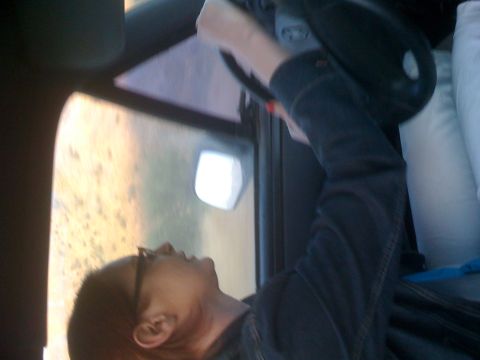 1992 Ford Bronco - A person looks out the window from the driver's seat of a vehicle.