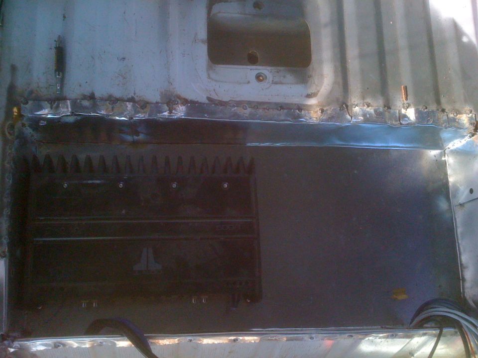 Interior view of a vehicle with a JL Audio amplifier mounted on the floor