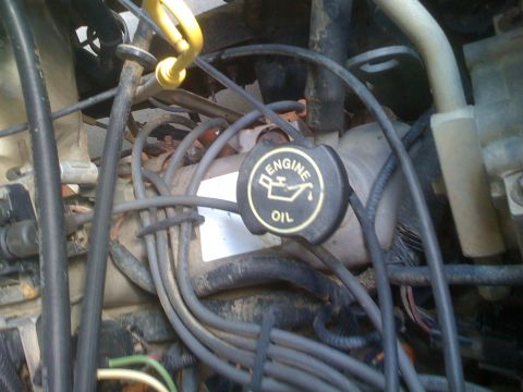1992 Ford Bronco - Close-up of an engine bay, the black engine oil cap with its distinctive graphic and text.