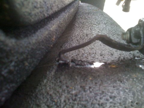 1992 Ford Bronco - This image shows a close-up of a vehicle component, possibly a brake caliper or suspension part, with a damaged wire.