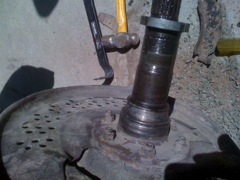 1992 Ford Bronco - Close-up of a vehicle's axle and brake rotor, with tools suggesting maintenance or repair.