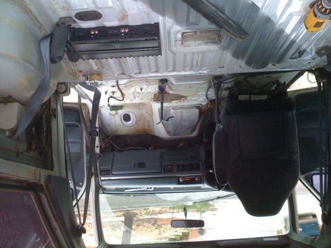 1992 Ford Bronco - The interior of a vehicle is shown with most of its components removed, revealing the bare structure and wiring.