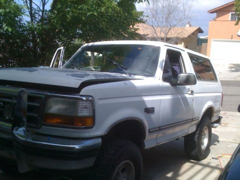 1992 Ford Bronco - This 1992 Ford Bronco is seen with its hood up, parked in a residential area.