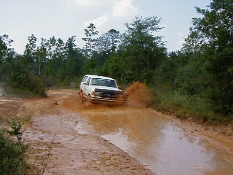 1990 Ford Bronco - This 1990 Ford Bronco kicks up a large spray as it navigates a muddy track.
