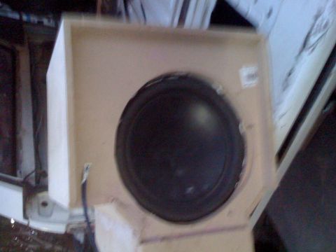 1992 Ford Bronco - A subwoofer is installed in a custom wooden enclosure, partially visible within a vehicle's interior.