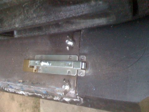 1992 Ford Bronco - Metal door latch hardware with visible bolts and a brass lock.
