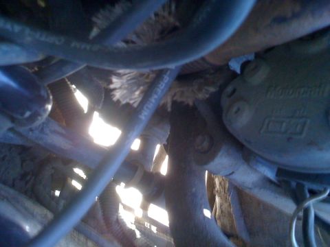1992 Ford Bronco - A close-up view of various engine components, including hoses and metal structures, with some text visible.