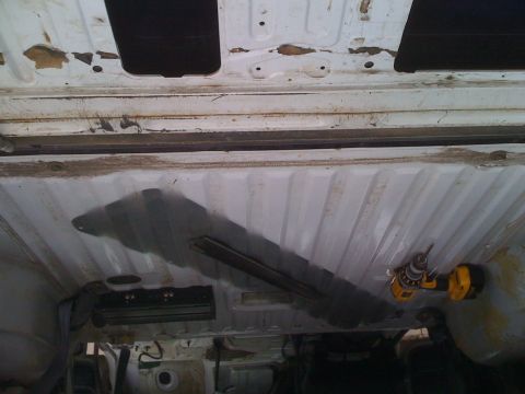 1992 Ford Bronco - Drilling into the underside of a vehicle, with Supermotors.net logo in the corner.