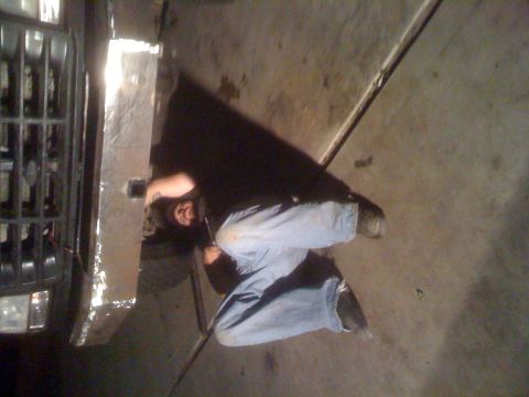 1992 Ford Bronco - A person works on the front bumper of a 1992 Ford Bronco.