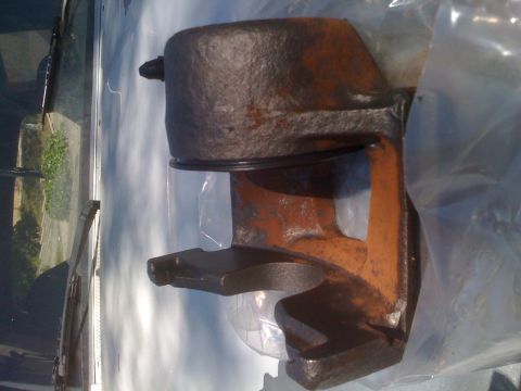 1992 Ford Bronco - A rusty brake caliper part is shown, partially wrapped in plastic.