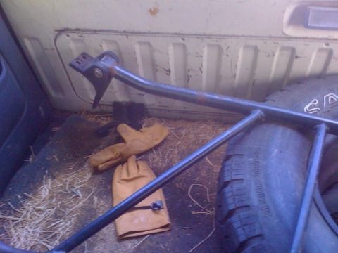 1992 Ford Bronco - The interior of a vehicle's cargo area shows a spare tire, work gloves, and some metal bars, with a Supermotors.net logo at the bottom.
