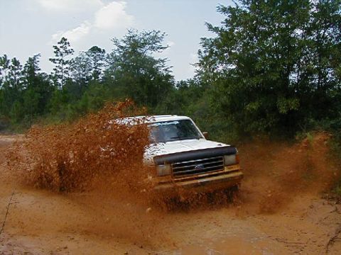 1990 Ford Bronco - This 1990 Ford Bronco kicks up a massive spray of mud as it navigates a muddy trail.